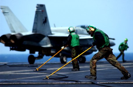 US Navy 050212-N-6363M-051 Sailors assigned to the Air Department aboard USS Harry S. Truman (CVN 75) use push bars to guide the arresting wire back into position after recovering an F-A-18C Hornet