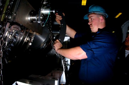 US Navy 050203-N-9273C-012 Aviation Machinist Mate 2nd Class Justin Thomas of Richmond, Calif., lines up the fan module to the high pressure compressor on a F414 jet engine