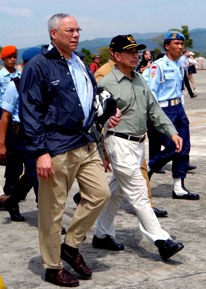 US Navy 050105-N-0057P-179 Secretary of State Colin Powell walks with the Indonesian Coordinating Minister for People's Welfare, Alawi Shihab, after departing his plane in Banda Aceh, Sumatra, Indonesia