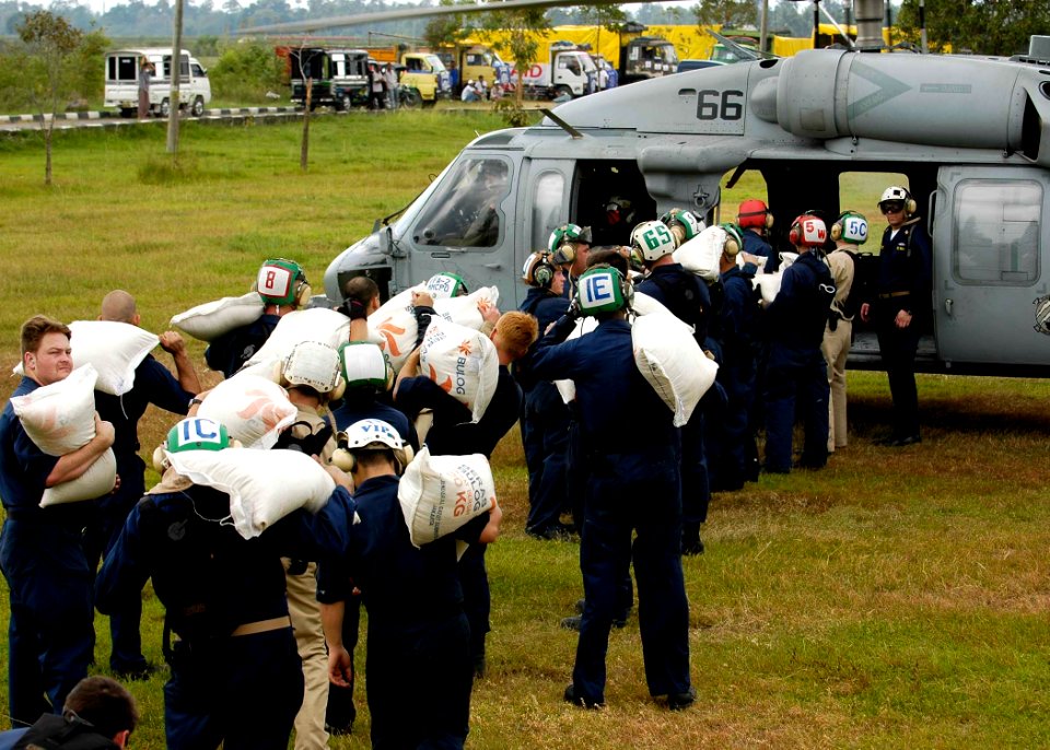 US Navy 050106-N-4166B-294 Sailors assigned to Carrier Air Wing Two (CVW-2) and USS Abraham Lincoln (CVN 72), load food into a MH-60S Knighthawk helicopter