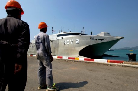 US Navy 050207-N-3642E-003 Dock workers stand ready to moor the High Speed Vessel Two (HSV-2) Swift as she prepares to dock at the Chuc Sumet Port in Sattahip, Thailand