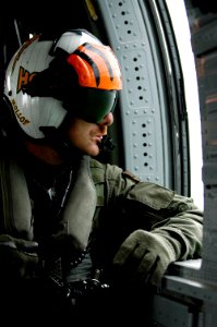 US Navy 050106-N-4166B-504 Aviation Structural Mechanic 1st Class John Molloy of Cincinnati, Ohio, looks out the window of an MH-60S Knighthawk helicopter
