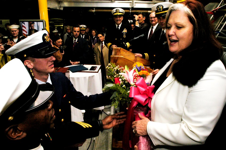 US Navy 050205-N-6477M-315 Ship Sponsor Mrs. Lynn Hunter receives flowers from Chief Boatswain's Mate Donald E. Murray, foreground, and Coast Guard Operation Specialist Seaman Jonathan L. Moore