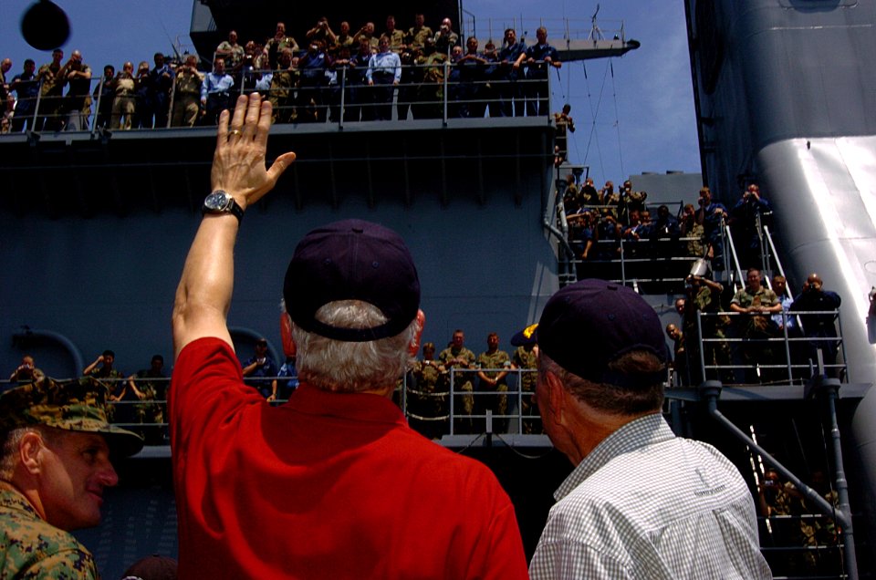 US Navy 050220-N-0000X-001 Former Presidents William J. Clinton, left, and George H. W. Bush wave to a large crowd of Sailors and Marines after arriving aboard the amphibious dock landing ship USS Fort McHenry (LSD 43)
