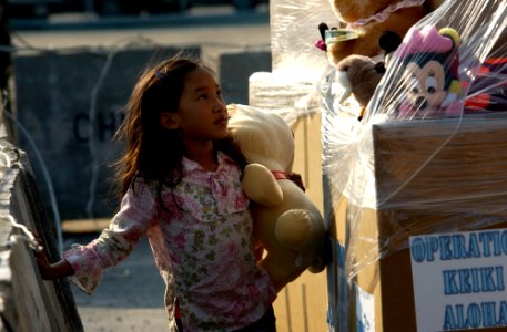 US Navy 050207-N-3642E-012 A child from Phuket, Thailand, picks out a toy on the Chuc Sumet Porton pier in Sattahip, Thailand
