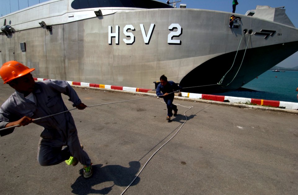 US Navy 050207-N-3642E-004 Dock workers work together to moor the High Speed Vessel Two (HSV-2) Swift to the pier at the Chuc Sumet Port in Sattahip, Thailand