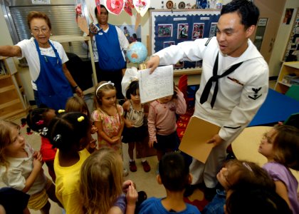US Navy 050209-N-3019M-002 Dental Technician 3rd Class Chris Mar hands out dental information sheets to children at the Child Development Center on board Naval Station Pearl Harbor, Hawaii