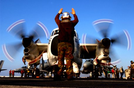 US Navy 050113-N-6363M-011 Airman Michael Cross, instructs the pilots of a C-2A Greyhound during start-up procedures aboard USS Harry S. Truman (CVN 75)