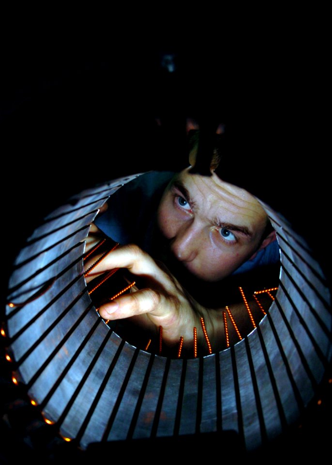 US Navy 050207-N-9273C-006 Electrician's Mate 3rd Class William Miller of Eldrado, Ark., inspects the windings of an electric motor for an air conditioning unit in the Motor Rewind Shop aboard the Nimitz-class aircraft carrier