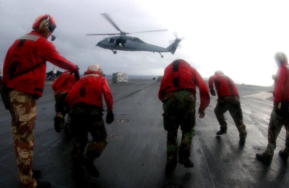 US Navy 050210-N-0905V-065 Sailors assigned to the Weapons Department, G-1 Division, aboard USS Carl Vinson (CVN 70), sprint to retrieve weapons during a vertical replenishment
