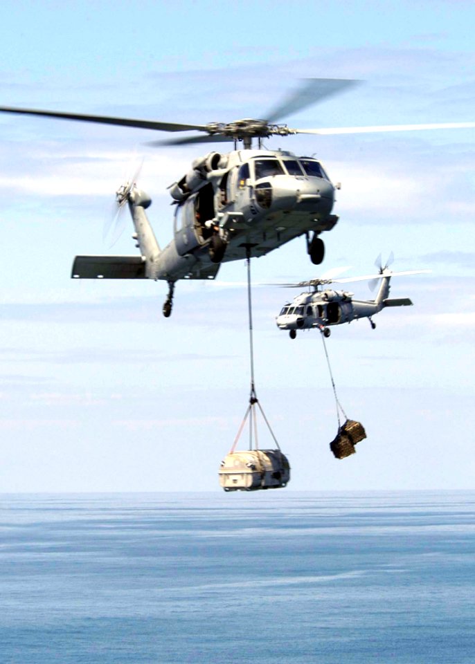 US Navy 050118-N-4336M-073 Two helicopters assigned to Carrier Air Wing Two (CVW-2) bring supplies from the Military Sealift Command combat stores ship USNS Niagara Falls (T-AFS 3) aboard the USS Abraham Lincoln (CVN 72)