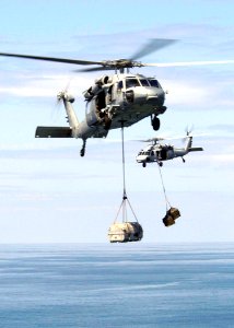 US Navy 050118-N-4336M-073 Two helicopters assigned to Carrier Air Wing Two (CVW-2) bring supplies from the Military Sealift Command combat stores ship USNS Niagara Falls (T-AFS 3) aboard the USS Abraham Lincoln (CVN 72)