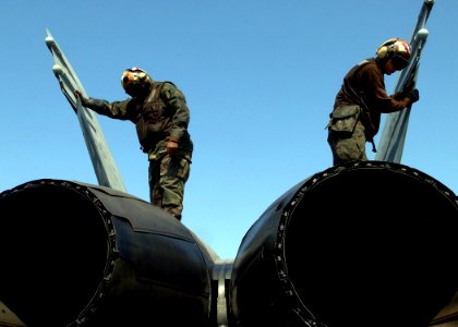 US Navy 050212-N-6363M-045 U.S. Marine Corps Cpl. Lee Sanders, left, and Lance Cpl. Michael Miller inspect an F-A-18A- Hornet prior to the commencement of flight operations aboard USS Harry S. Truman (CVN 75)