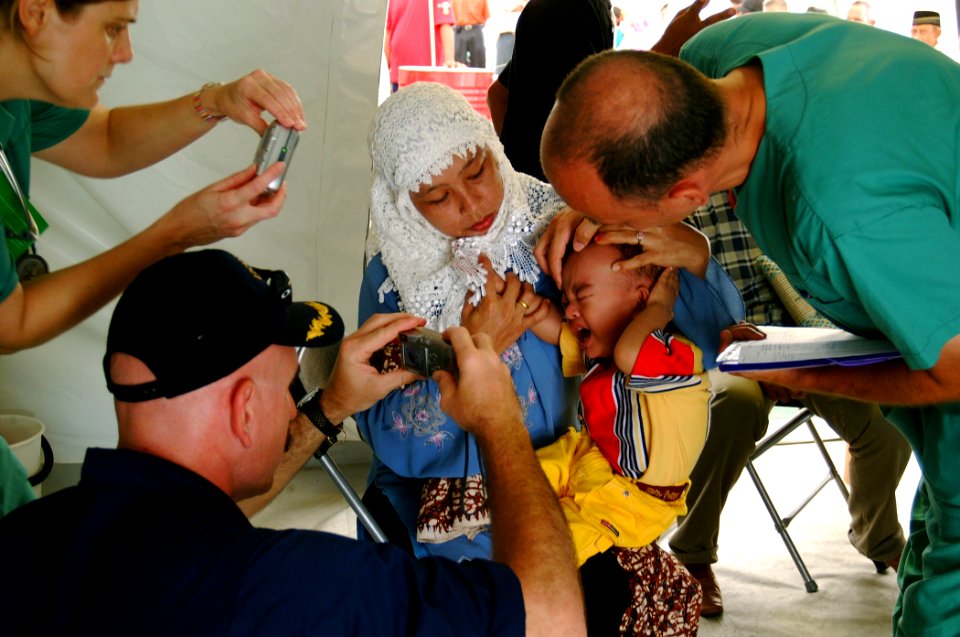US Navy 050212-N-0357S-085 Cmdr. Kurt Hummeldorf of the U.S. Navy Dental Corps, takes photographs of an Indonesian child with a retinal tumor