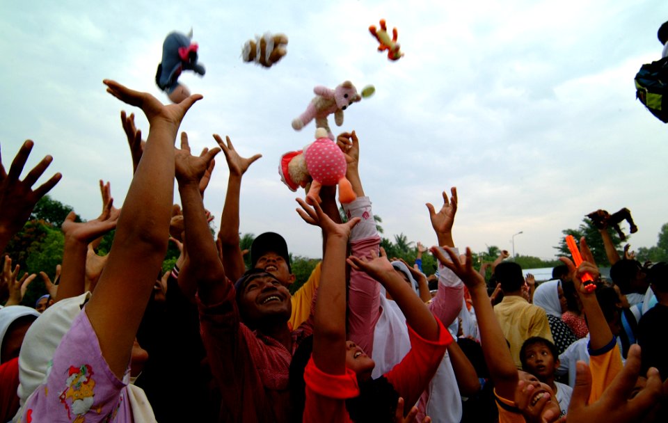 US Navy 050214-N-0357S-071 A group of Indonesians living in a camp for internally displaced persons in Banda Aceh on the island of Sumatra, Indonesia, reach for stuffed animals thrown to them by Sailors