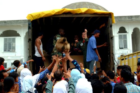 US Navy 050214-N-0357S-052 Lt. Allison Johnson, assigned as Air Operations Officer aboard the Military Sealift Command (MSC) hospital ship USNS Mercy (T-AH 19), throws a stuffed animal to a group a Indonesians