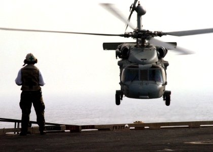 US Navy 050305-N-6363M-029 A Safety Observer watches as an MH-60S Seahawk helicopter climbs over the fantail of USS Harry S. Truman (CVN 75) during a vertical replenishment