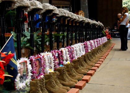 US Navy 050307-N-3019M-003 A family member reflects in front of a ceremonial formation of U.S. Marine Corps infantry equipment during the First Battalion, Third Marine's Memorial Service at the Hawaii State Capitol Buildi