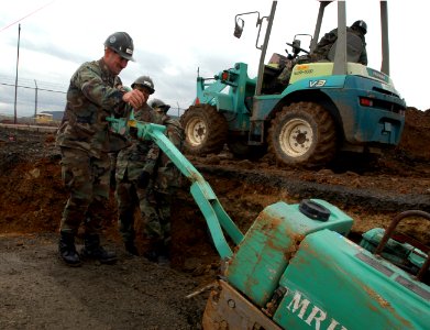 US Navy 050215-N-2385R-079 Equipment Operator 3rd Class Robert Chord, assigned to Naval Mobile Construction Battalion Four Zero (NMCB-40), Detachment Sasebo, operates a walk behind roller to compact the gravel over a foundation