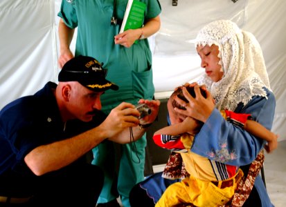US Navy 050212-N-0357S-086 Cmdr. Kurt Hummeldorf of the U.S. Navy Dental Corps, takes photographs of an Indonesian child with a retinal tumor