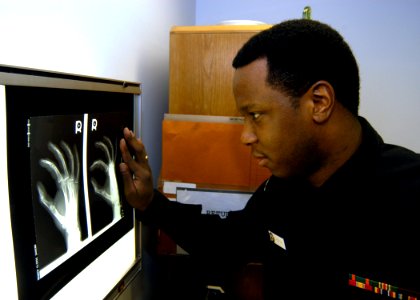US Navy 050311-N-2385R-020 Hospital Corpsman 3rd Class Antonio Robinson, checks an X-ray of a patient's hand, at the Branch Health Clinic Sasebo, Japan
