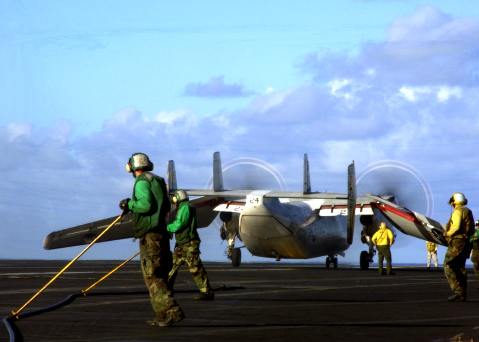 US Navy 050225-N-3241H-050 Air Department personnel guide an arresting cable after the successful recovery of a C-2A Greyhound