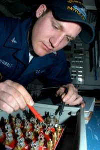 US Navy 050315-N-3390M-278 Electrician's Mate 3rd Class Michael Vanderwalt, troubleshoots a fuse box with a multimeter aboard the guided missile frigate USS Ingraham (FFG 61)