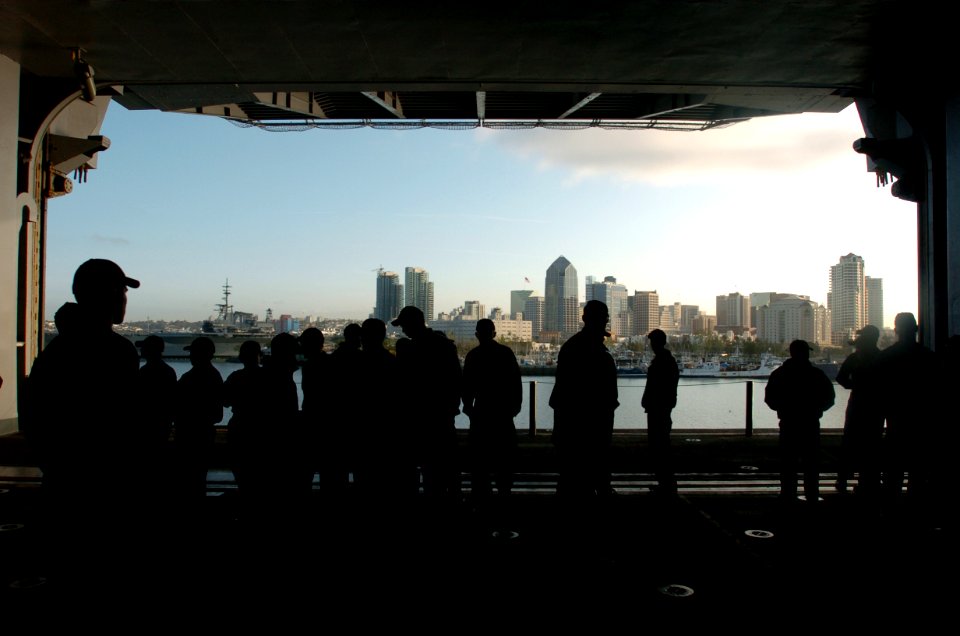 US Navy 050302-N-9866B-001 Sailors watch the San Diego, Calif., skyline pass by them from inside the hanger bay aboard the amphibious assault ship USS Peleliu (LHA 5)