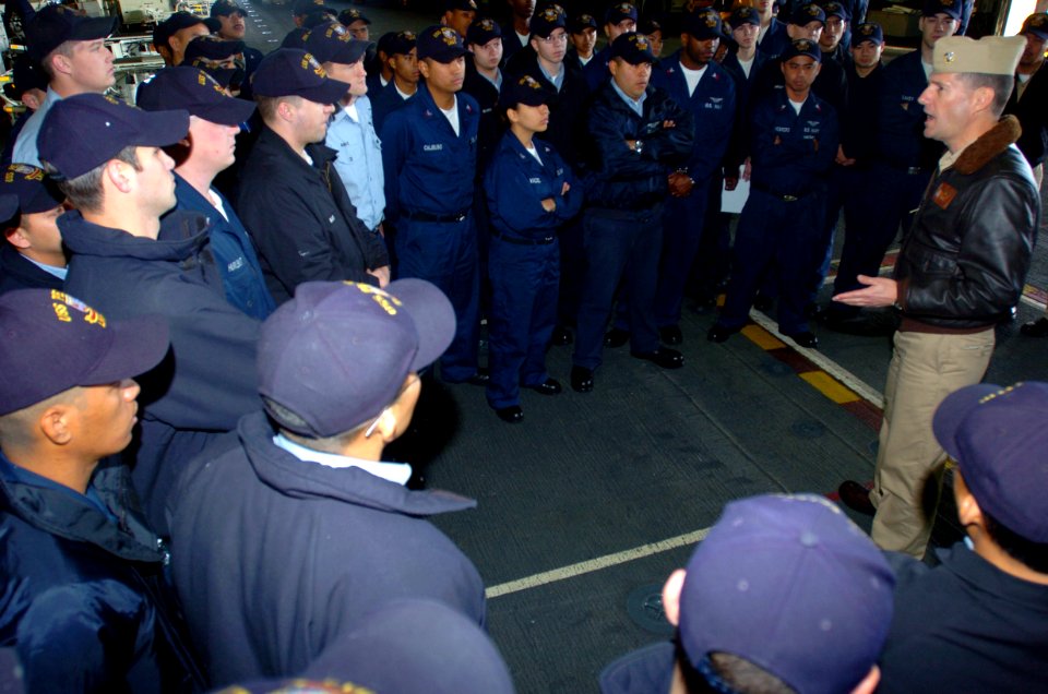 US Navy 050302-N-9866B-003 Air Boss, Cmdr. James Cox, talks to his Sailors in Air Department during a daily muster in the hanger bay aboard the amphibious assault ship USS Peleliu (LHA 5)