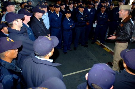 US Navy 050302-N-9866B-003 Air Boss, Cmdr. James Cox, talks to his Sailors in Air Department during a daily muster in the hanger bay aboard the amphibious assault ship USS Peleliu (LHA 5)