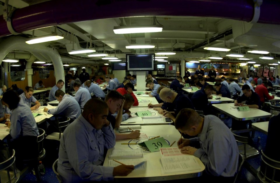 US Navy 050317-N-0361G-007 E-3 Sailors aboard the nuclear powered aircraft carrier USS Nimitz (CVN 68), take the semi-annual Navy-Wide Advancement Exam on the mess decks