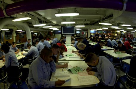 US Navy 050317-N-0361G-007 E-3 Sailors aboard the nuclear powered aircraft carrier USS Nimitz (CVN 68), take the semi-annual Navy-Wide Advancement Exam on the mess decks