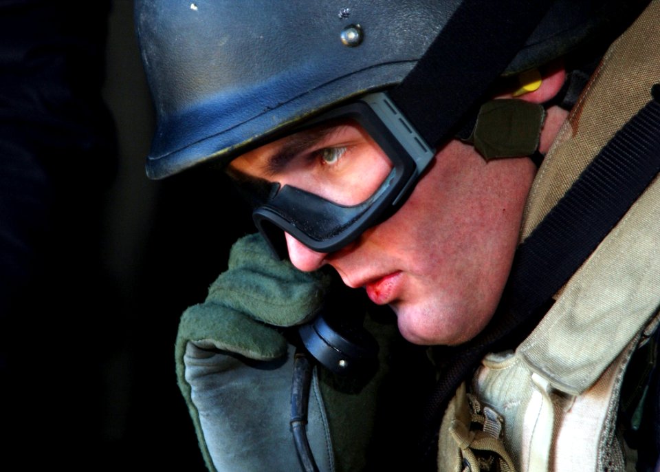 US Navy 050304-N-4374S-006 A member of Explosive Ordnance Disposal Mobile Unit Six (EODMU-6) performs a communication check during a Combat Search and Rescue (CSAR) exercise aboard a UH-3H Sea King helicopter