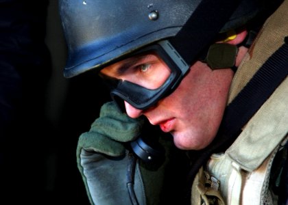 US Navy 050304-N-4374S-006 A member of Explosive Ordnance Disposal Mobile Unit Six (EODMU-6) performs a communication check during a Combat Search and Rescue (CSAR) exercise aboard a UH-3H Sea King helicopter