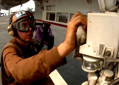 US Navy 050309-N-3488C-086 Aviation Structural Mechanic Airman Edward Constantino of Pittsburgh, Pa., cleans the approach lights on the nose landing gear of an F-A-18F Super Hornet