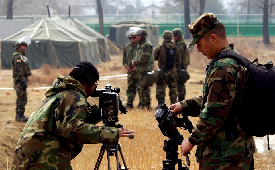 US Navy 050322-F-2902B-192 U.S. Army Spc. Burey, a videographer for AFN Korea, left, and U.S. Navy combat videographer, Photographer's Mate 2nd Class Bradley Sapp, document a simulated enemy prisoner of war camp at Camp Wonju,