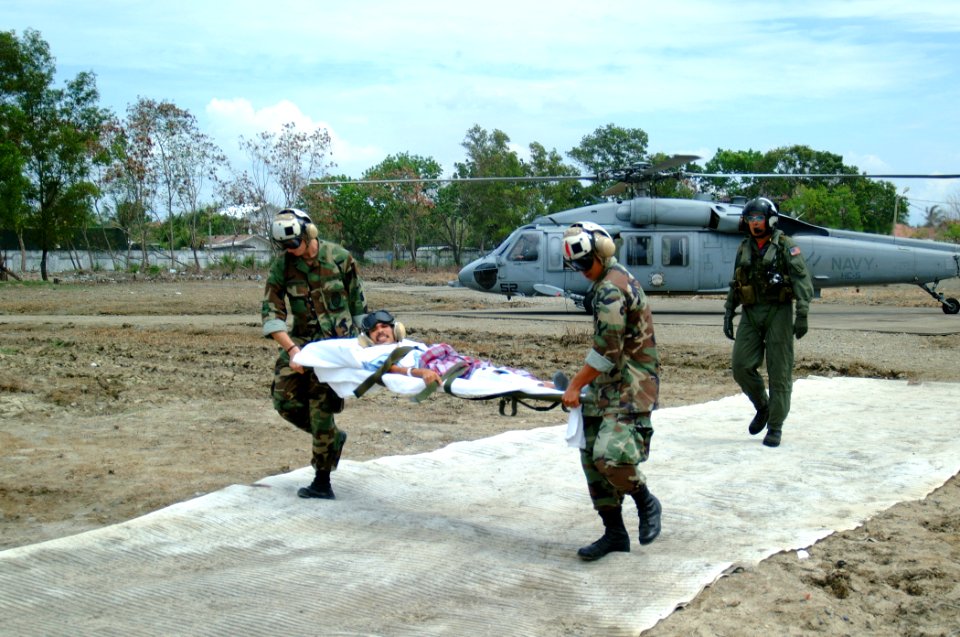 US Navy 050212-N-0357S-114 Two U.S. Navy Sailors carry an injured Indonesian man on a stretcher from an MH-60S Seahawk helicopter