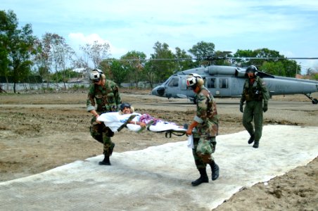 US Navy 050212-N-0357S-114 Two U.S. Navy Sailors carry an injured Indonesian man on a stretcher from an MH-60S Seahawk helicopter photo