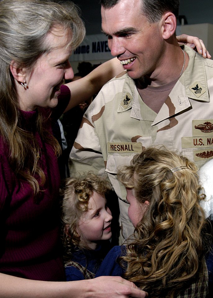 US Navy 050320-N-4048T-035 Storekeeper 1st Class David Presnall is greeted by his loved ones after returning from deployment at the Air Mobility Command Terminal on board Naval Station Norfolk, Va.