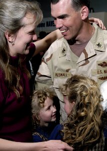 US Navy 050320-N-4048T-035 Storekeeper 1st Class David Presnall is greeted by his loved ones after returning from deployment at the Air Mobility Command Terminal on board Naval Station Norfolk, Va.