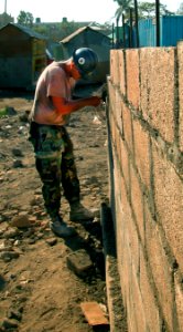 US Navy 050310-N-1464F-011 Builder Constructionman Apprentice Dustin Baugus, assigned to Naval Mobile Construction Battalion One (NMCB-1), lays bricks to construct a new three-room schoolhouse for children in Gonaives, Haiti