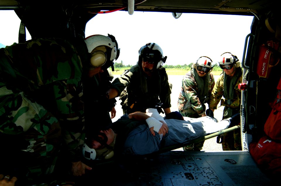 US Navy 050405-N-0357S-008 U.S. Navy Hospital Corpsmen and aircrew men assist in unloading a patient from a U.S. Navy MH-60S Seahawk helicopter