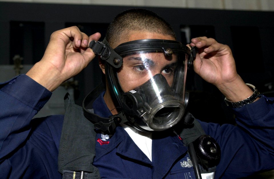 US Navy 050319-N-0361G-077 Damage Controlman 2nd class Ronaldo Longoria of Denver, Colo., demonstrates the proper way to don a Self Contained Breathing Apparatus (SCBA) aboard the nuclear powered aircraft carrier USS Nimitz (CV