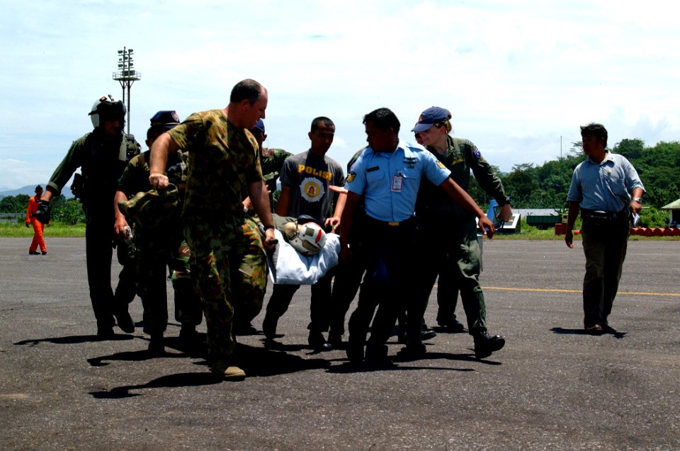 US Navy 050405-N-0357S-006 Australian service members, Indonesian police officers and U.S. Navy aircrew men carry an injured Royal Australian Navy Sailor to an awaiting Australian C-130 Hercules aircraft