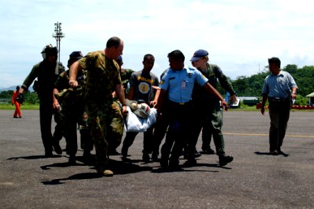 US Navy 050405-N-0357S-006 Australian service members, Indonesian police officers and U.S. Navy aircrew men carry an injured Royal Australian Navy Sailor to an awaiting Australian C-130 Hercules aircraft