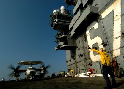 US Navy 050217-N-8704K-003 Aviation Boatswain Mate 3rd Class Zolli Goodman directs the movement of an E-2C Hawkeye