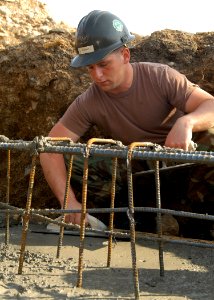 US Navy 050321-N-2385R-017 Steel Worker 3rd Class Mat Martin, assigned to Naval Mobile Construction Battalion Four Zero (NMCB-40), Detachment Sasebo, uses a magnesium float to even out concrete