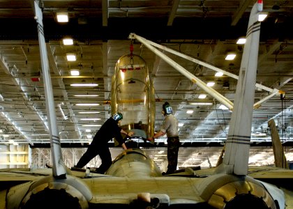 US Navy 050321-N-6363M-002 Two Sailors assigned to the Swordsmen of Fighter Squadron Three Two (VF-32), guide a canopy back into place on an F-14B Tomcat in the hangar bay aboard the Nimitz-class aircraft carrier
