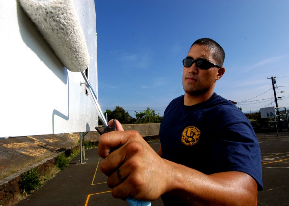 US Navy 050324-N-3019M-001 Machinist's Mate 2nd Class Rick Parizal, assigned to Mobile Diving Salvage Unit One (MDSU-1), applies a layer of paint to a basketball backboard