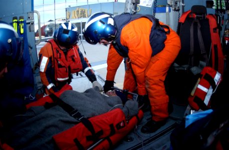 US Navy 050317-C-0000L-002 U.S. Coast Guard Petty Officer 1st Class Brian Laubenstein and Petty Officer 1st Class Travis Cholewa, prepare to transfer an injured fisherman from the cabin of an HH-60 Jayhawk helicopter